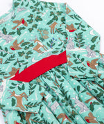 A close up of the front of the Frugi party skater dress in festive forest available at Babipur. A GOTS organic cotton dress in mint green with a playful winter / festive print. Features a red tie around the waist