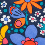 A close up of the details on the print of the Frugi sofia skater dress in navy / retro flowers available at Babipur. A GOTS organic cotton skater dress in navy with a bright retro floral design.