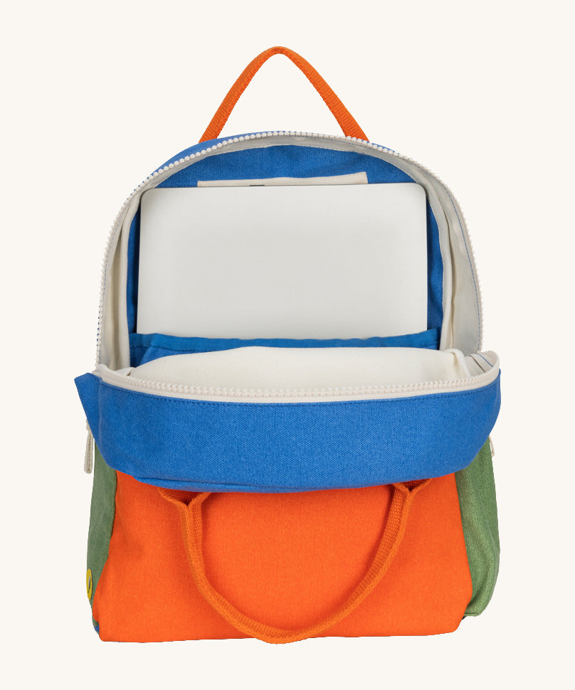 The organic cotton kids Fluf B-Pack Jr in cobalt orange, the backpack is unzipped and there's a small laptop inside.