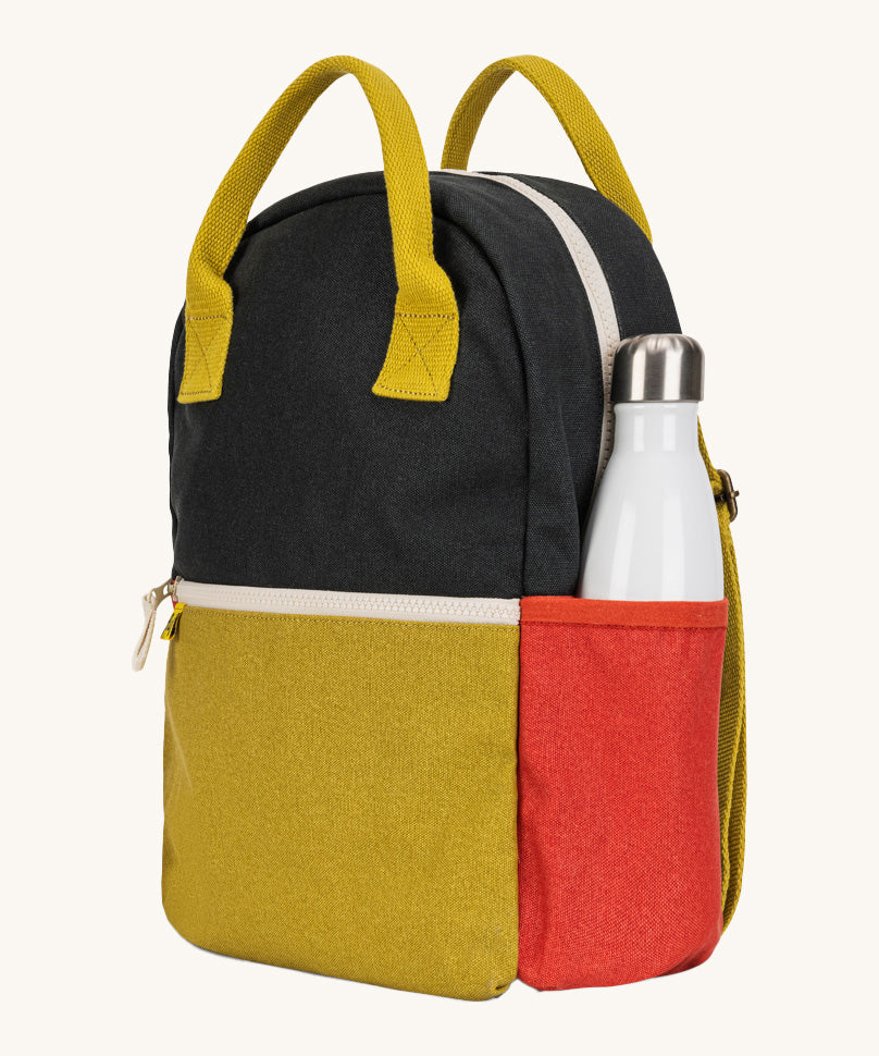 A side view of The organic cotton Fluf B-Pack Jr in carbon cactus, a kids school backpack with a red drink holder side pocket