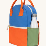 A side view of The organic cotton Fluf B-Pack Jr in cobalt orange, a kids school backpack with a green drink holder side pocket
