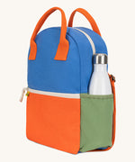 A side view of The organic cotton Fluf B-Pack Jr in cobalt orange, a kids school backpack with a green drink holder side pocket