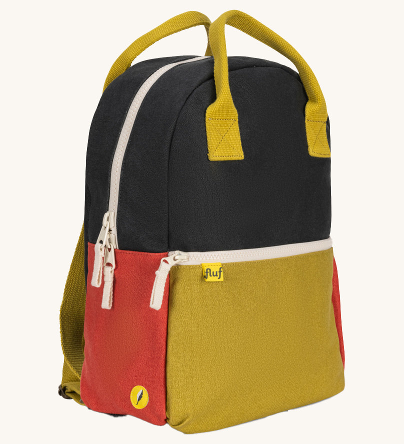A side view of The organic cotton Fluf B-Pack Jr, a kids school backpack in a black, mustard and red