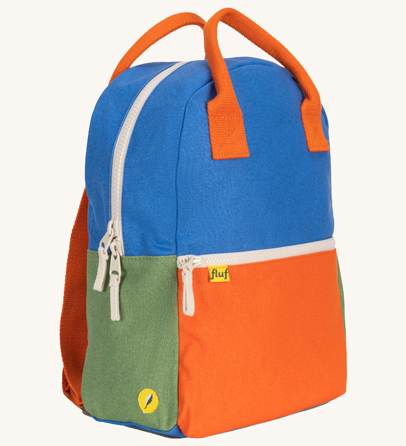 A side view of The organic cotton Fluf B-Pack Jr in cobalt blue, a kids school backpack in blue, orange and green