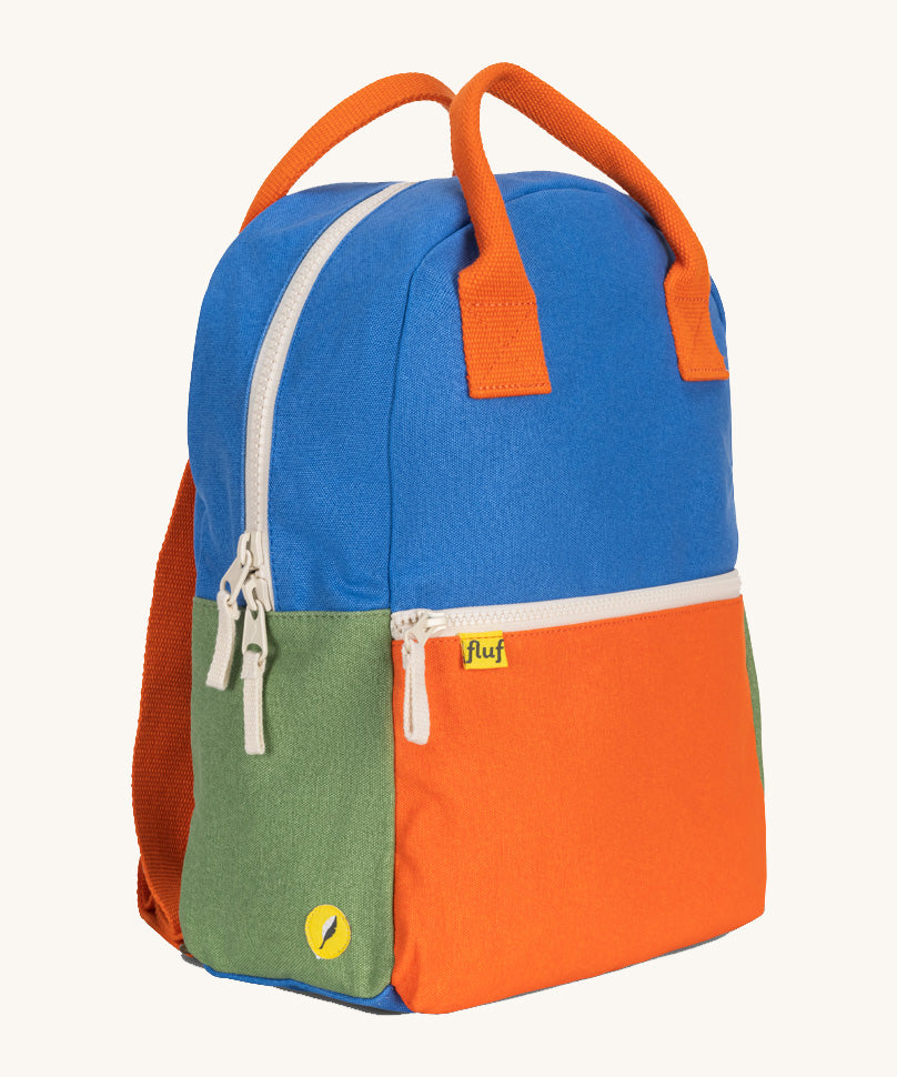 A side view of The organic cotton Fluf B-Pack Jr in cobalt blue, a kids school backpack in blue, orange and green