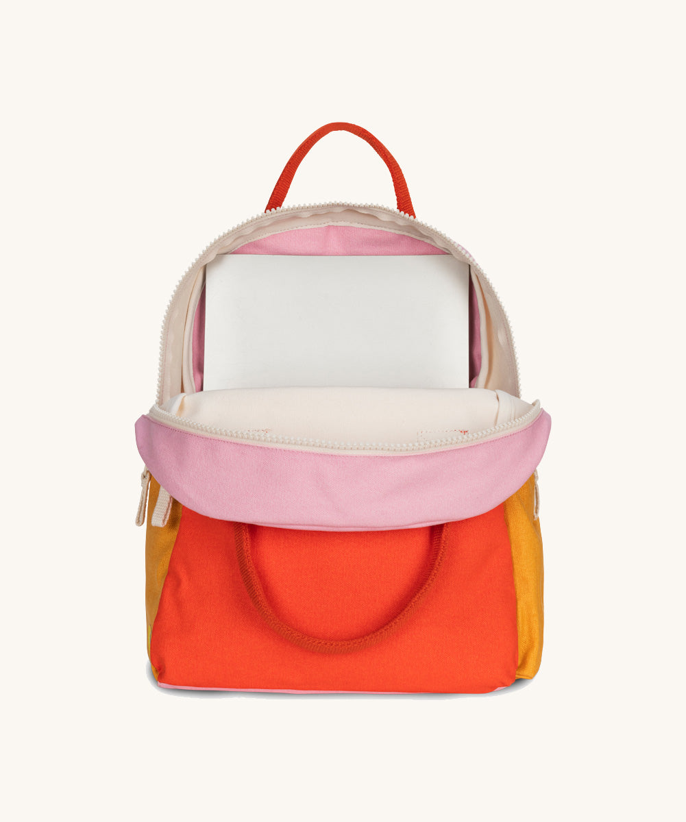 The organic cotton kids Fluf B-Pack Jr, the backpack is unzipped and there's a small laptop inside.
