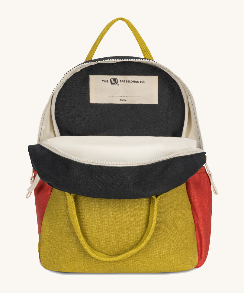 The organic cotton Fluf B-Pack Jr in carbon cactus, a kids school backpack, unzipped to show the name tag inside.