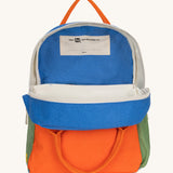 The organic cotton Fluf B-Pack Jr in cobalt orange, a kids school backpack, unzipped to show the name tag inside.