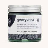 A jar of the Georganics activated fluoride toothpaste on a cream background