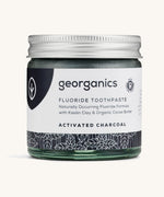 A jar of the Georganics activated fluoride toothpaste on a cream background