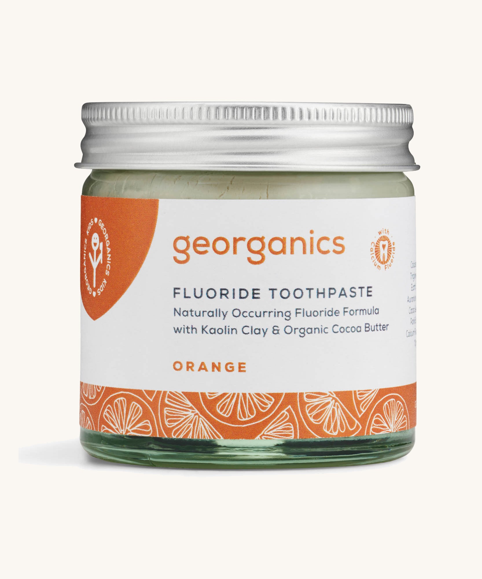 a jar of the Georganics orange fluoride toothpaste on a cream background