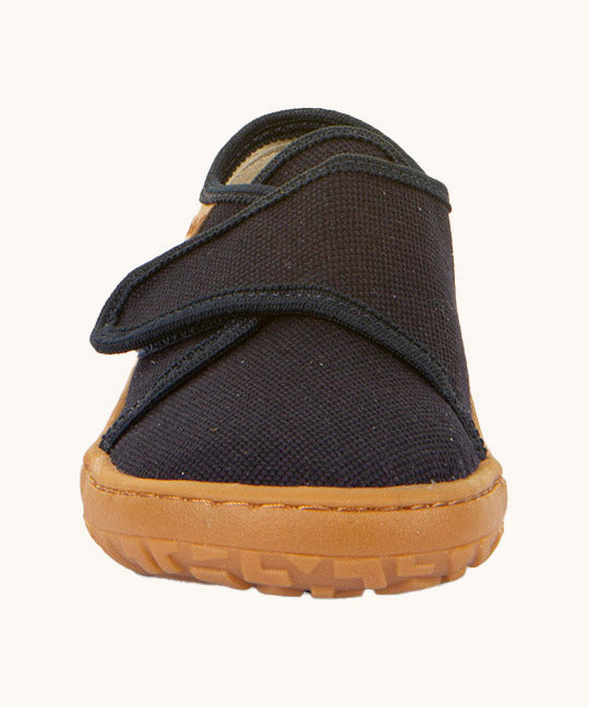 The front of the Froddo barefoot kids slipper in dark blue available at Babipur. showing the velcro strap and grippy sole detail