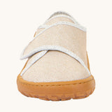 The front of the Froddo barefoot kids slipper in gold shine available at Babipur. showing the velcro strap and grippy sole detail
