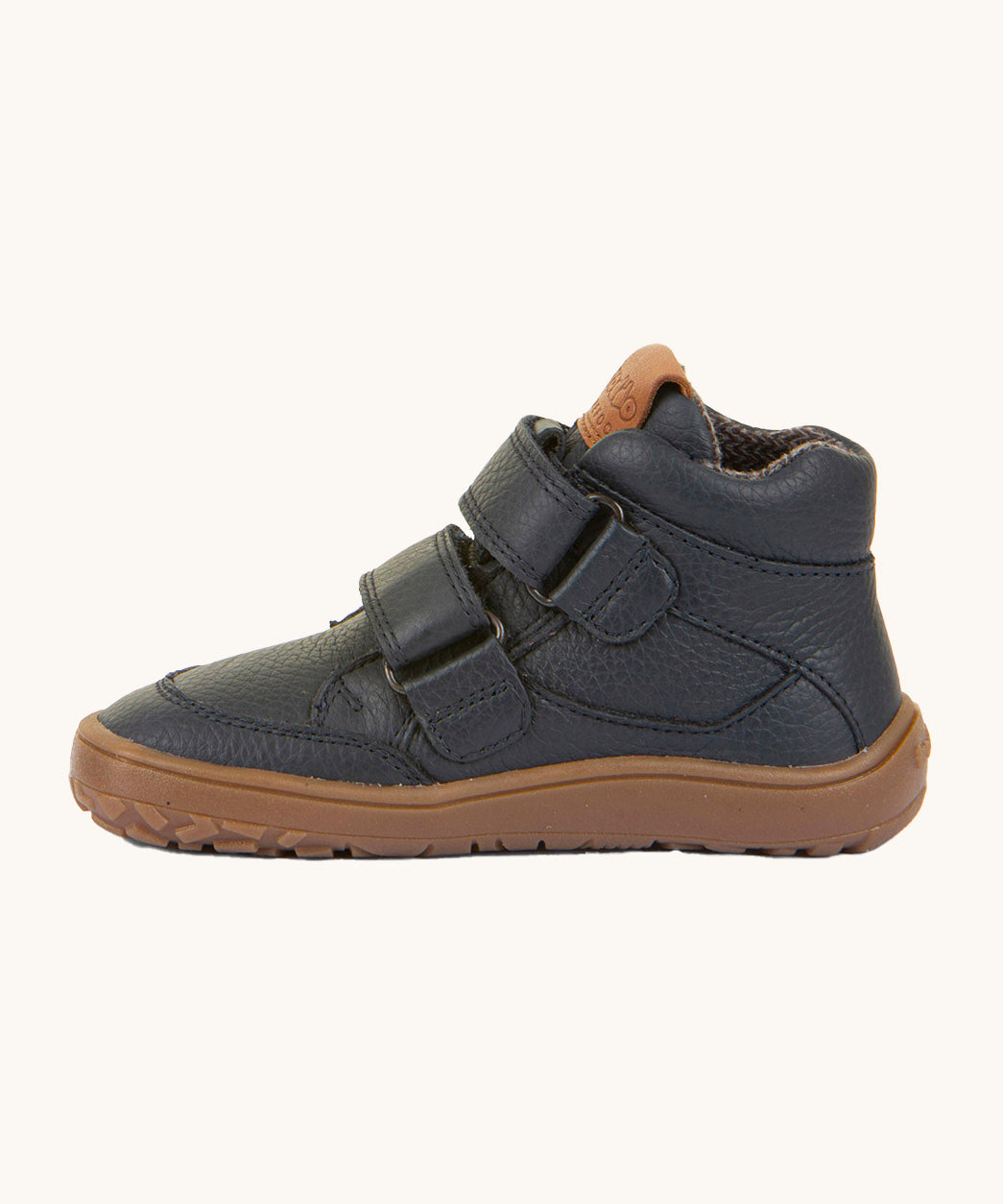 A side image of a Froddo barefoot Autumn children's shoe in navy available at Babipur showing the 2 velcro fastener for a secure fit, padded ankle and the dark brown grippy sole