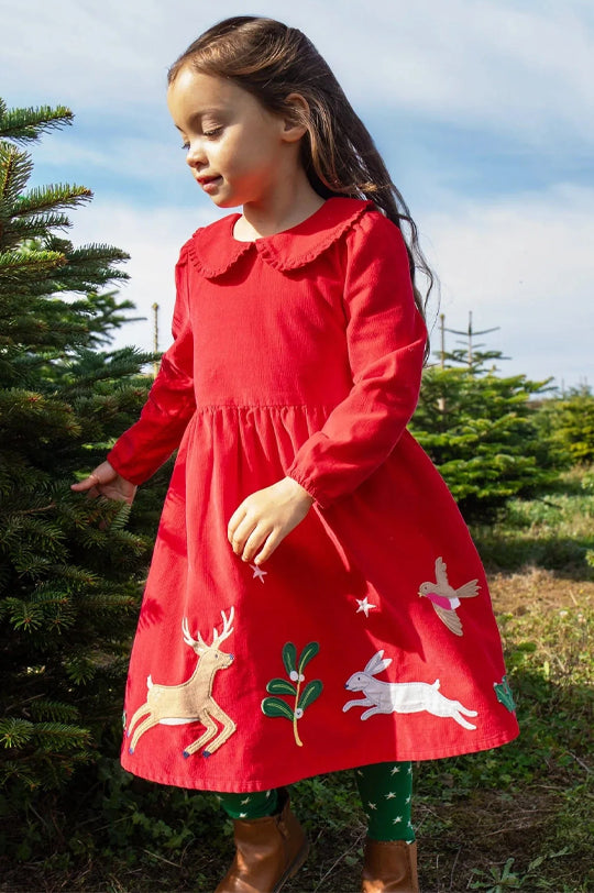 Child wearing an organic cotton Frugi Peony Corduroy Christmas Dress Red Robin to represent Frugi baby and children's clothing at Babipur.