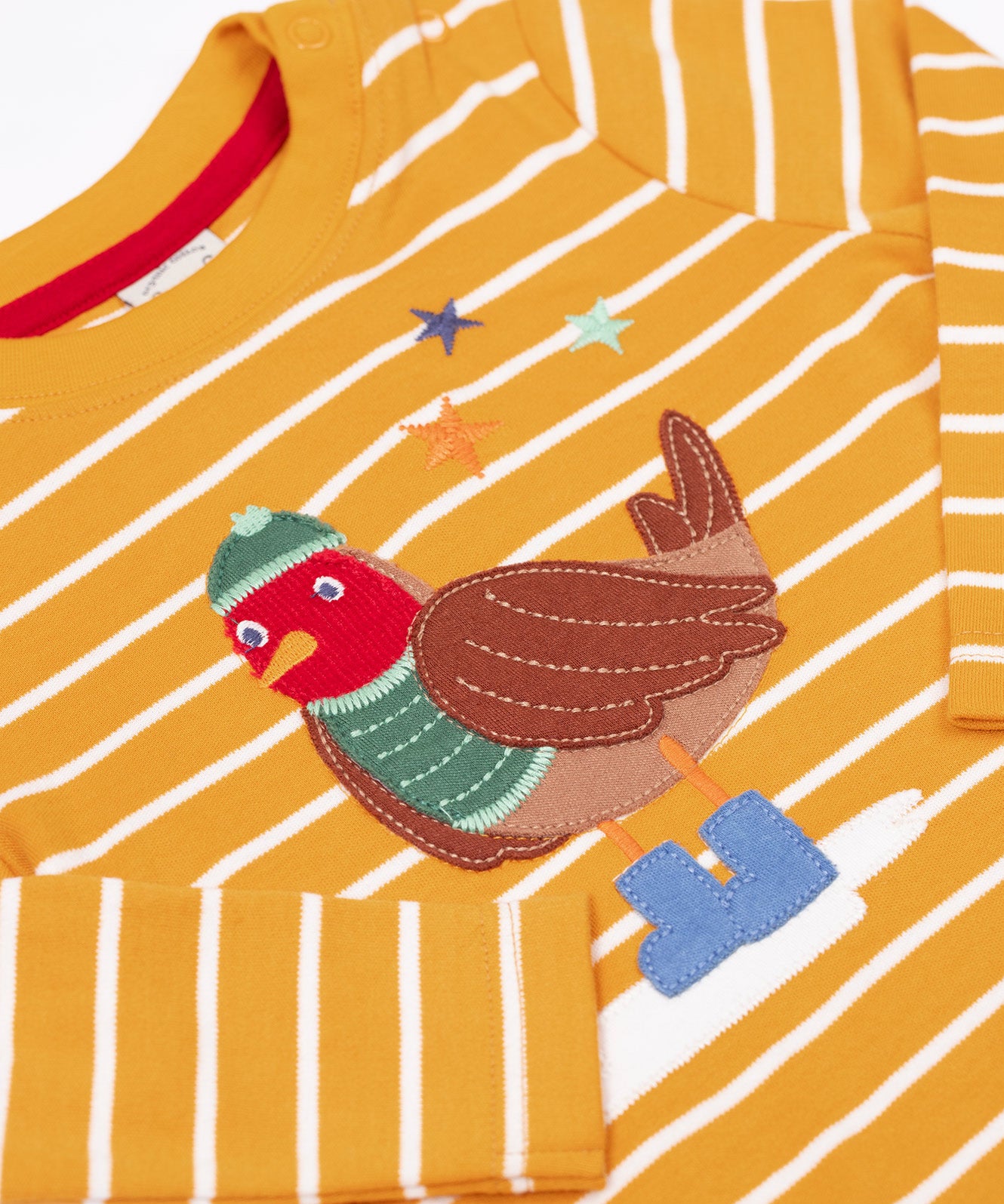 A close up of the robin applique on the Frugi discovery applique top in stripe/polar bear available at Babipur. Robin is wearing a greeb winter hat, top and blue boots.