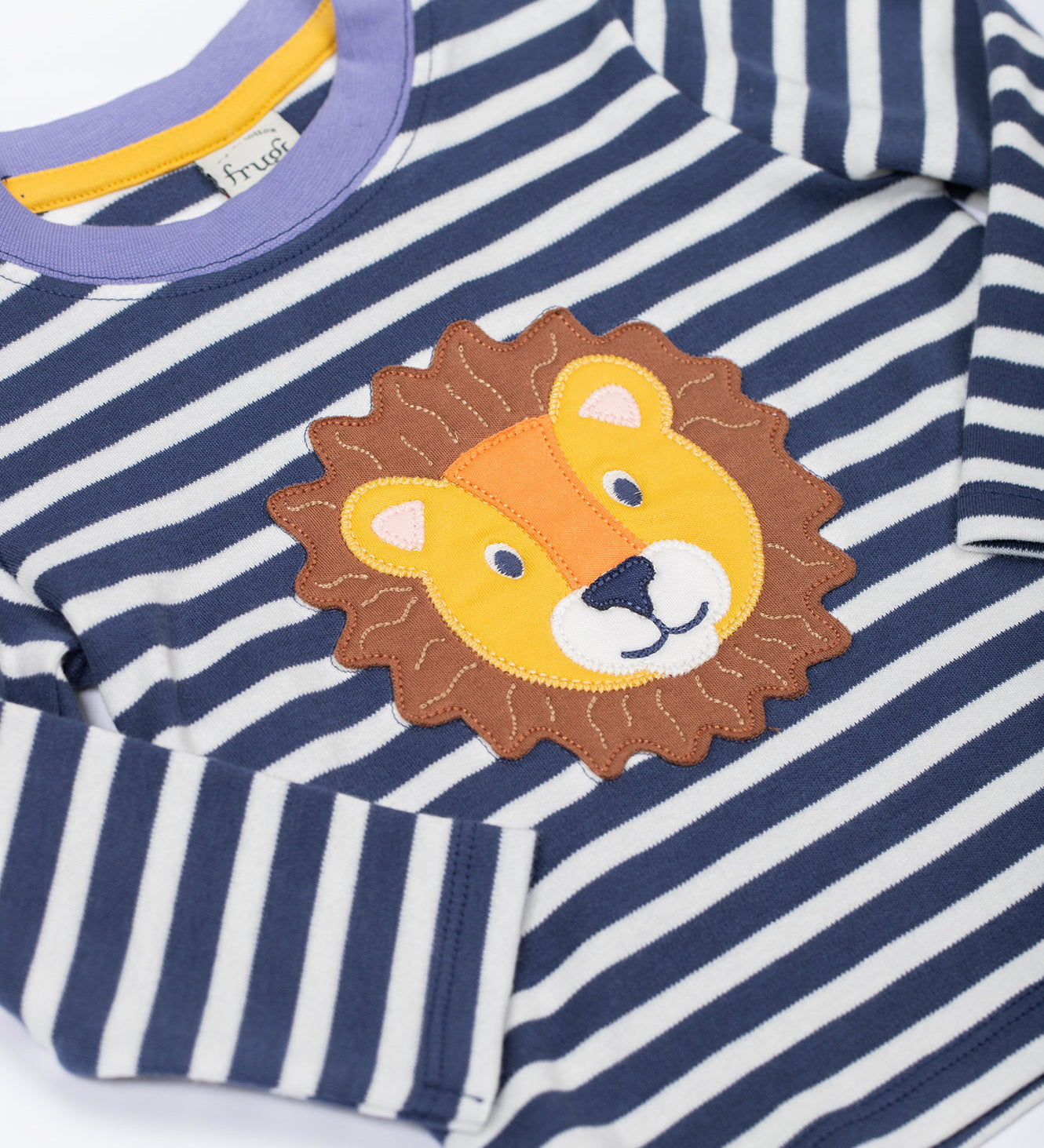 A close up of the Frugi discovery applique top in stripe/Lion available at Babipur showing the applique detail and light blue trim on the neck