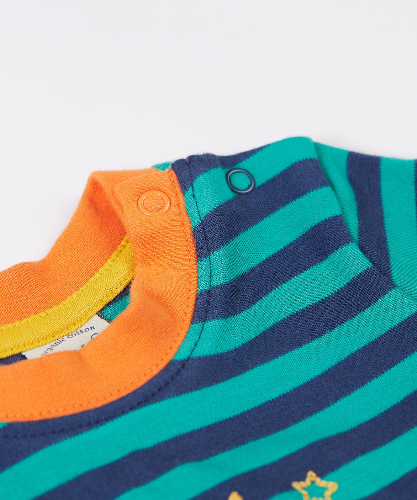 A close up of the popper fastner on the shoulder on the Frugi discovery applique top in stripe/polar bear available at Babipur.