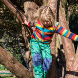 A child Playing in the trees and wearing the Frugi Autumn stripe ted fleece available at Babipur.. A long sleeve striped thick fleece with light blue trim and turn up collar.