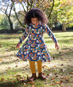 A child wearing the Frugi Magic Skies Organic Cotton Cosy Skater Dress. This party dress is a part of a wide range of organic cotton clothing for children available here at Babipur.
