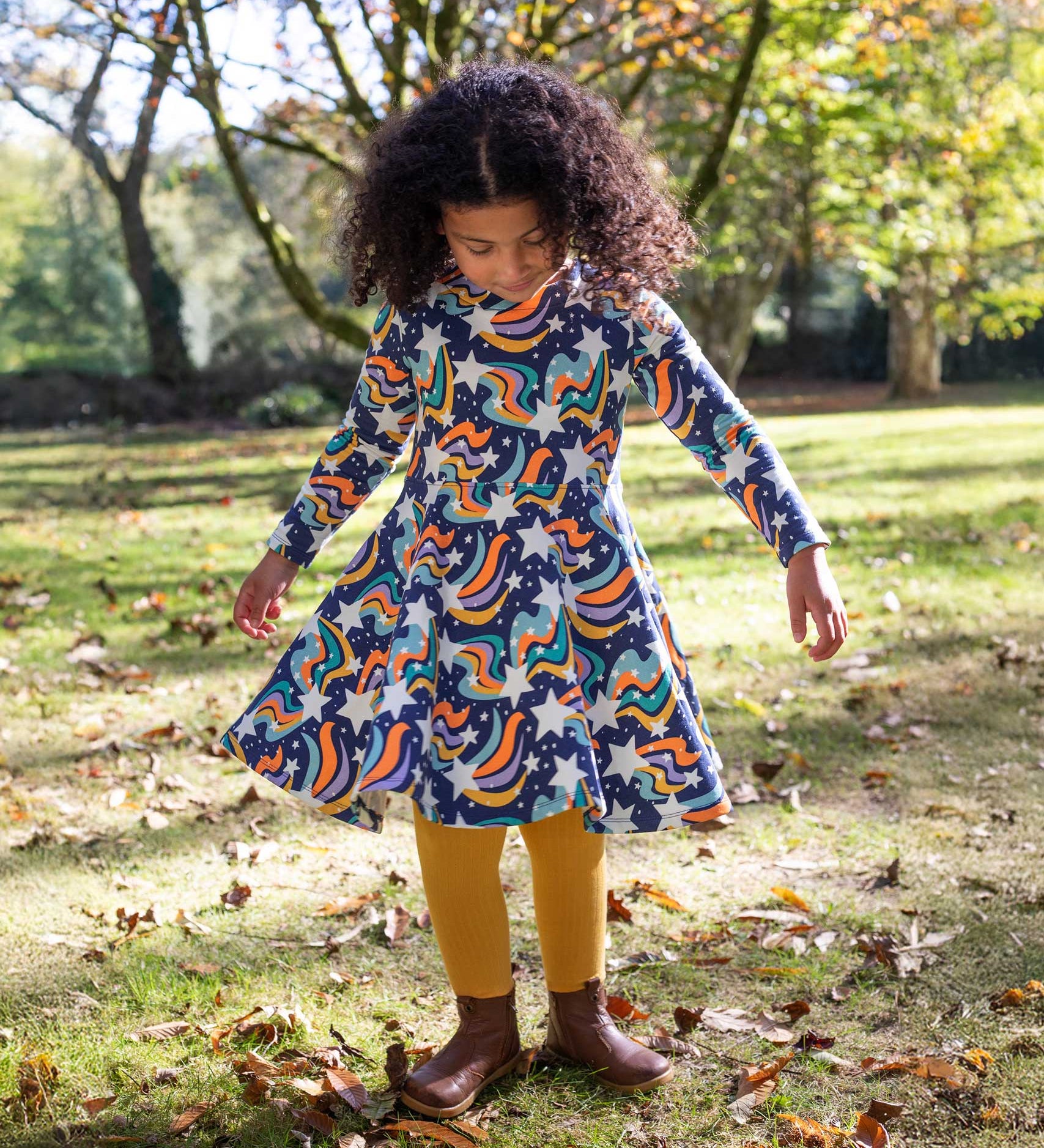 A child wearing the Frugi Magic Skies Organic Cotton Cosy Skater Dress. This party dress is a part of a wide range of organic cotton clothing for children available here at Babipur.