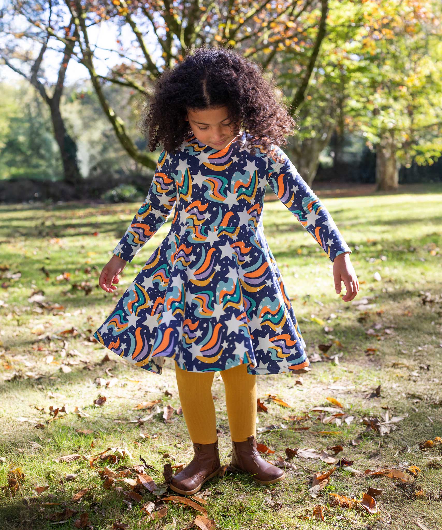 A child wearing the Frugi Magic Skies Organic Cotton Cosy Skater Dress. This party dress is a part of a wide range of organic cotton clothing for children available here at Babipur.