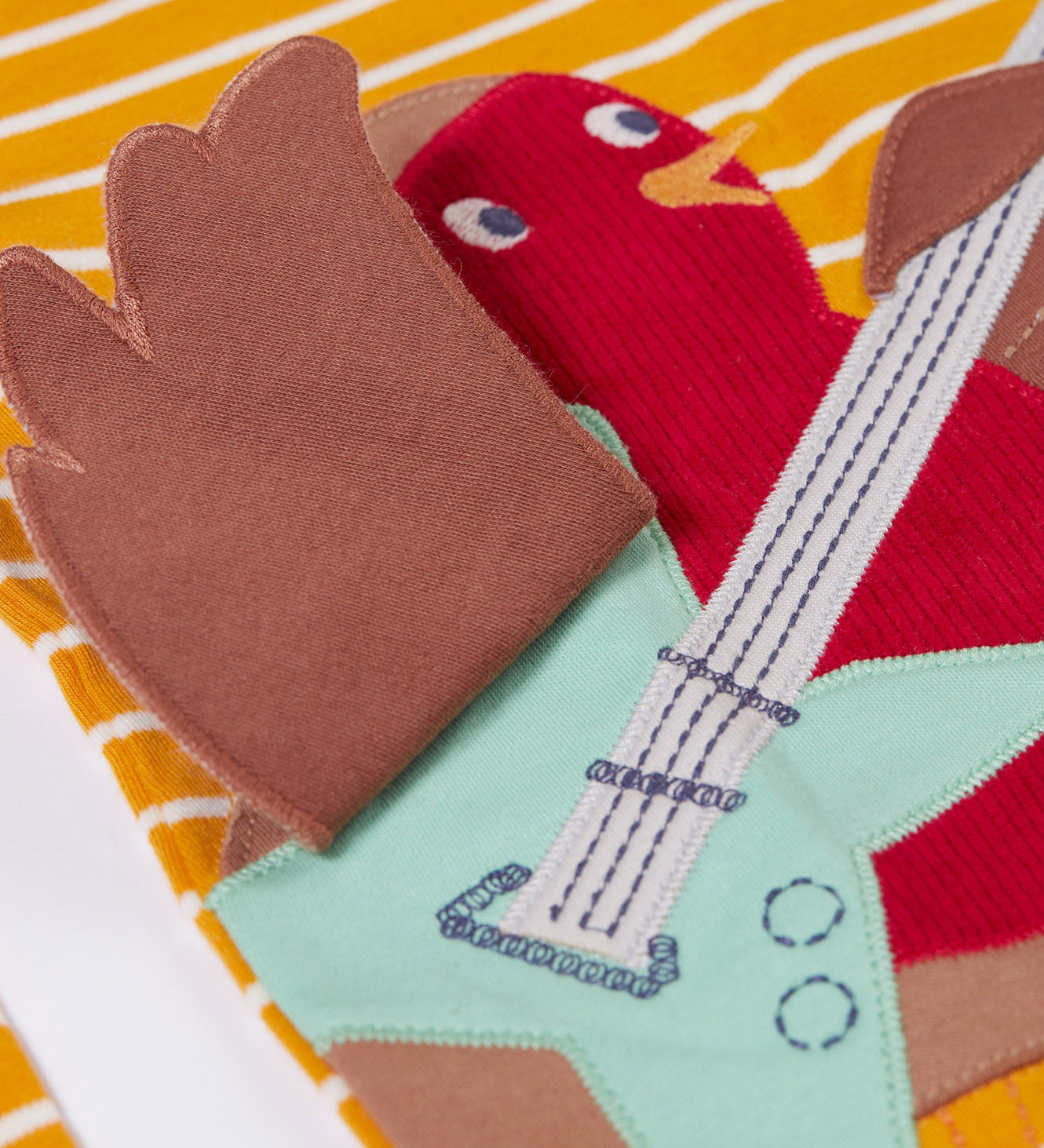 A close up of the Frugi Gold Rockin' Robin Summit Circular Organic Cotton Top available at Babipur showing the wing detail on the robin applique