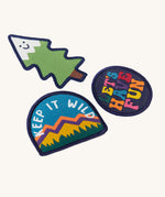 A close up of the Frugi kids keep it wild patches showing the different designs. Features a playful tree patch, a keep it wild slogan patch and lets have fun slogan patch.