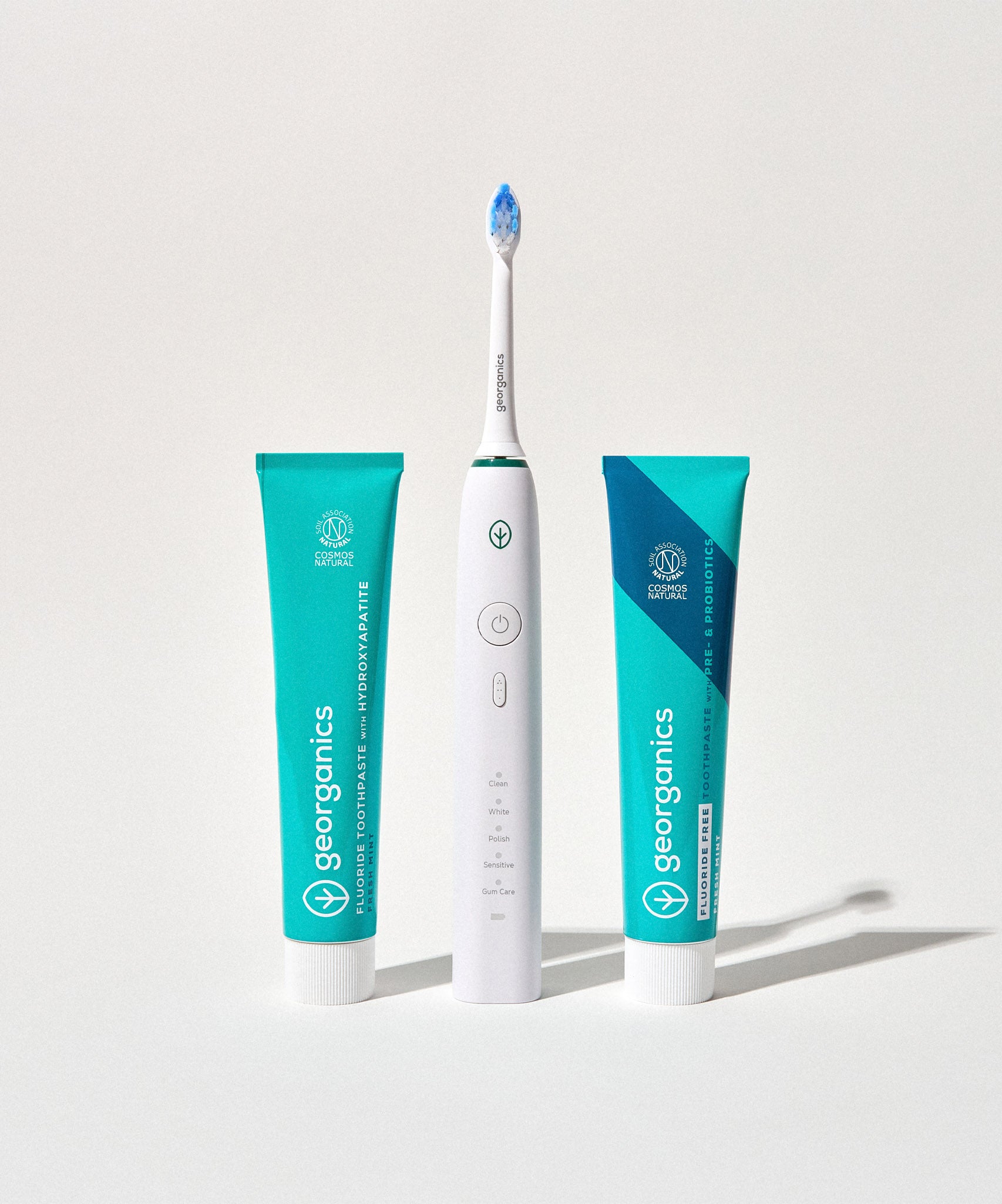 Georganics fluoride free toothpaste with pre and prebiotcs in fresh mint flavour available at Babipur standing next to a Georganics sonic toothbrush and fresh mint toothpaste with fluoride