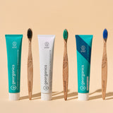A group of Georganics toothpastes available at Babipur standing next to Georganics bamboo toothbrushes