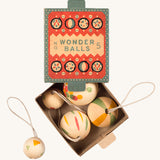 A opened teal and coral cardboard box for the wooden Grapat wonder balls on a cream background