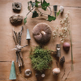 A flatlay image using the different piece from the Grapat advent calendar available at Babipur and various woodland leaves, miss and mushrooms.
