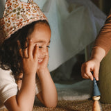 A child playing with the handmade and hand painted wooden nin peg doll from the Grapat advent calendar 2025 available at Babipur.