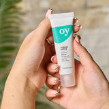 A person holding the Green People OY! Organic Teen Purifying Serum - 30ml in their hands, showing the front of the tube