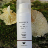 The Green People Nordic Roots Truffle Night Cream is laid on a mossy background with two yellow chanterelle mushrooms