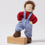Grimm's Brown Haired Doll - Peter is resting its foot on a block of wood with its arms bent towards its side, to show the flexibility of the dolls limbs