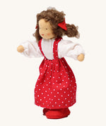 Grimm's Brown Haired Girl Doll - Lana, has brown hair and is wearing a white top under a red dress with white spots all over and is Waldorf inspired. The image is on a cream background