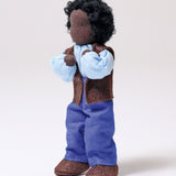 Grimm's Handmade Doll - Mr Ebony is stood up with its arms bent towards its face at the elbows, showing off the flexibility of the doll. The image is on a light grey background