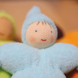 A closer look at the Grimm's Light Blue Pastel Dwarf face to show the doll's smiling face. The light blue dwarf doll has a red smile, light pink rosy cheeks, blue eyes and 4 brown painted strands of hair.