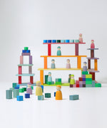 The Grimm's 12 Pastel Friends stood on various levels of a built Grimm's wooden block building