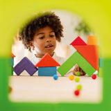 Two building blocks have been put together to create a window effect, and looking through you can see a child playing with small colourful marbles and the Grimm's Basic Building Set