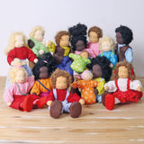 The Grimm's Doll collection all together, on a wooden table and a light grey background