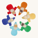 Grimm's Rainbow Dwarfs, placed in a circle. Each doll is one colour of the rainbow and is light blue, dark blue/indigo, red, orange, yellow or green. Each doll has a warm smiling face a long beard and a pointed hat. The image is on a cream background