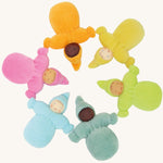 Grimm's Pastel Dwarfs, placed in a circle. Each doll is one colour of the rainbow and is light blue, teal, green, yellow and pink. Each doll has a warm smiling face and a pointed hat. The image is on a cream background