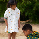Two children playing at the beach, with the child on the left wearing the LGR Adventure Hooded Beach Towel Poncho