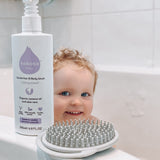 Kokoso unscented organic baby body and hair wash 200ml bottle standing on the side of the bath with a baby inside. Bottle available at Babipur