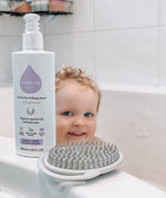 Kokoso unscented organic baby body and hair wash 200ml bottle standing on the side of the bath with a baby inside. Bottle available at Babipur