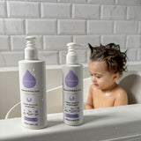 Kokoso unscented organic baby body and hair wash 200ml bottle standing on the side of the bath next to the baby lotion. Both are available at Babipur.