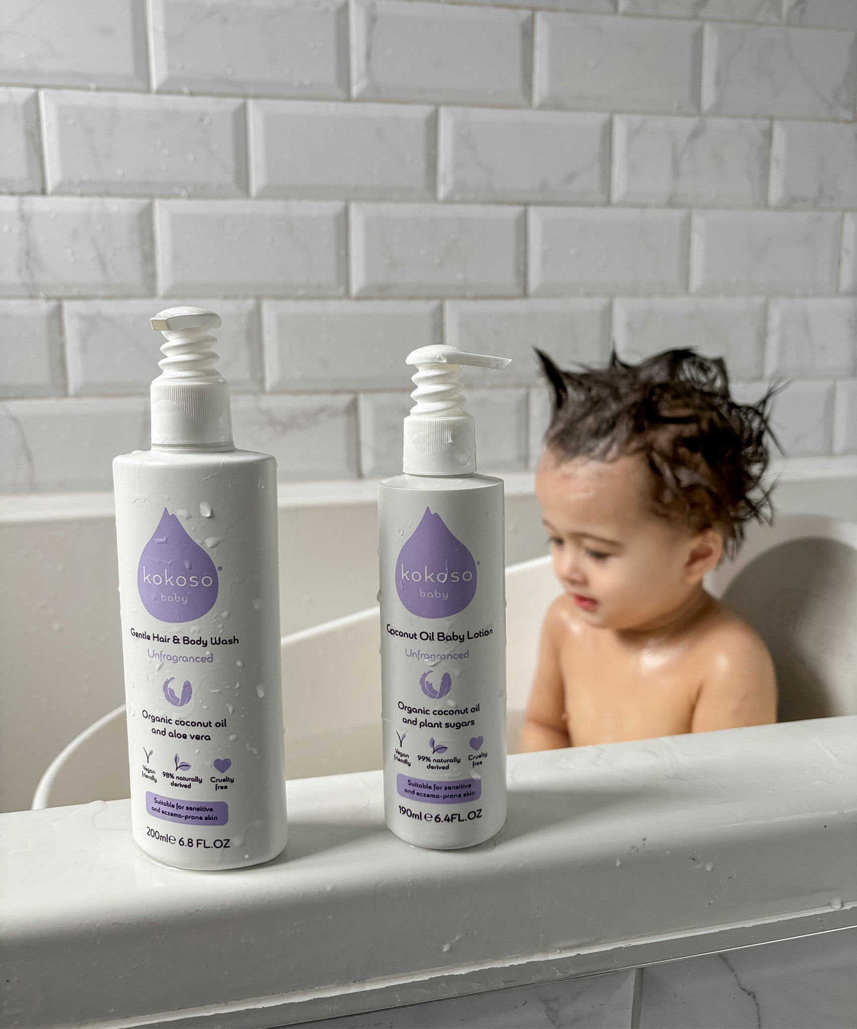 Kokoso unscented organic baby body and hair wash 200ml bottle standing on the side of the bath next to the baby lotion. Both are available at Babipur.