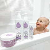 Kokoso unscented organic baby body and hair wash 200ml bottle standing on the side of the bath next to the baby lotion, balm and coconut oil, all are available at Babipur.